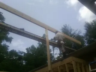 Carpenter setting a ridge beam over a new addition frame — Ice Dam Removal by Roofing Brothers in Decatur